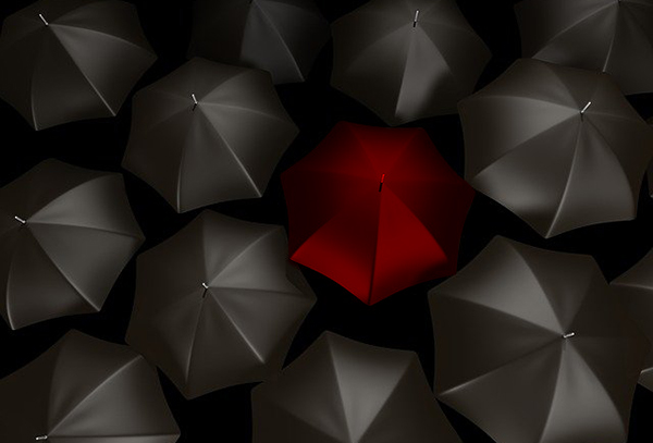 red umbrella with lots of black umbrellas